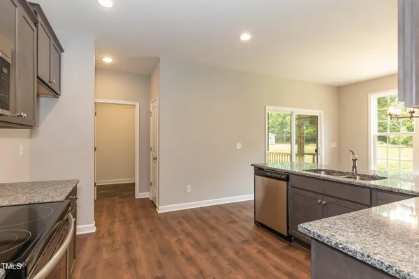 an empty room with wooden floor a fireplace and windows