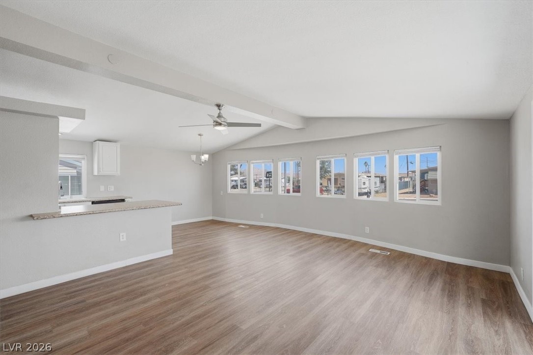 283 Aztec Lane Henderson, NV 89015 - Photo 9 of 21 An airy living area offers seamless flow, anchored by durable wood-look flooring and a functional breakfast bar.