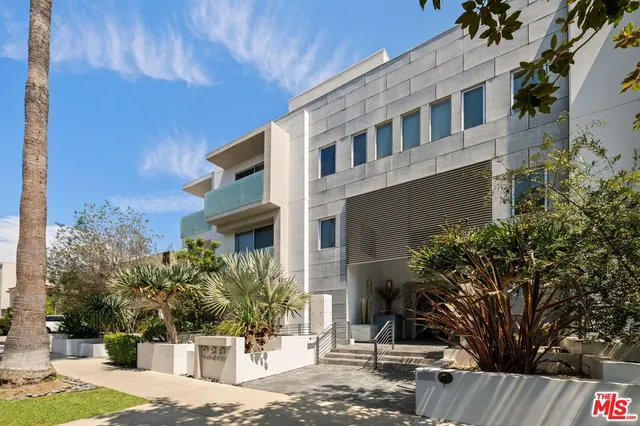a view of a building with potted plants and large trees