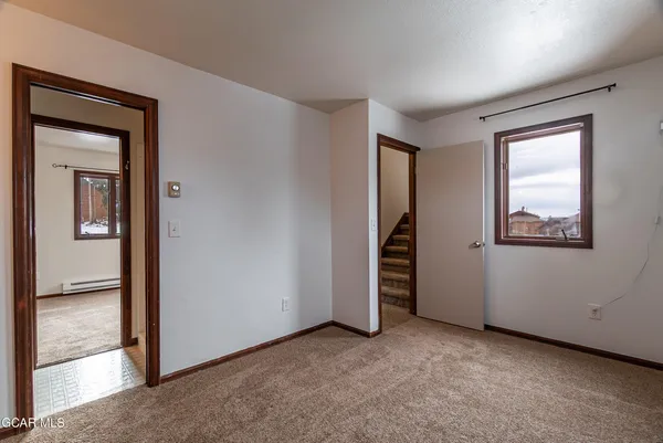 an empty room with closet and windows