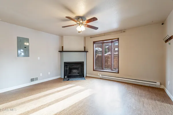an empty room with windows and fireplace