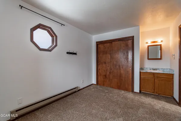 an empty room with mirror and a bathroom