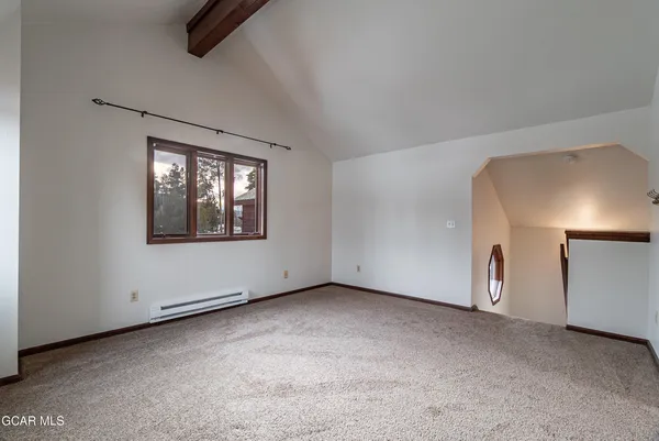 an empty room with chandelier fan and windows