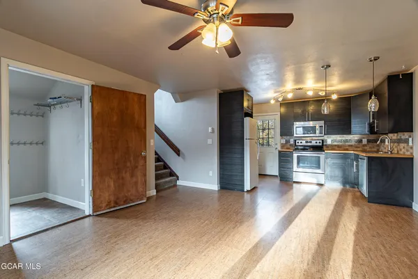 a view of kitchen with cabinets appliances and a ceiling fan