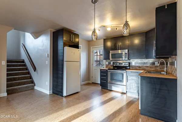 a kitchen with stainless steel appliances kitchen island a refrigerator and a stove top oven