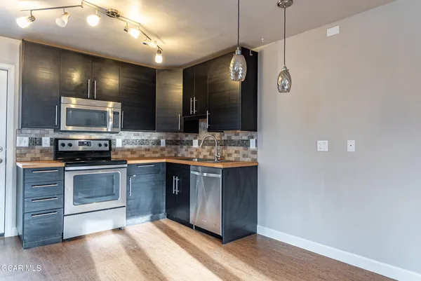a kitchen with kitchen island granite countertop stainless steel appliances and wooden floor