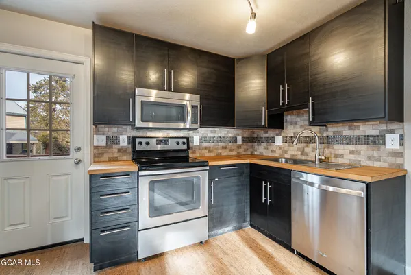a kitchen with stainless steel appliances granite countertop a stove and a sink