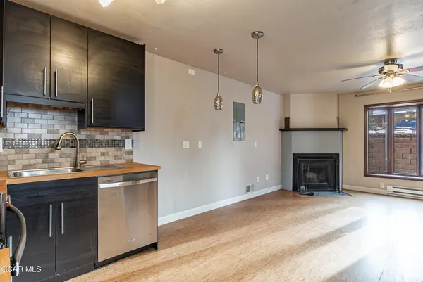 a kitchen with stainless steel appliances granite countertop a stove a refrigerator and a sink with wooden floor