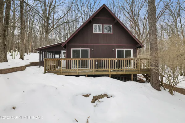 a front view of a house with a yard covered in snow