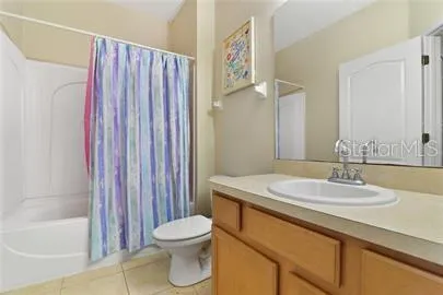 a bathroom with a sink a toilet and shower curtain