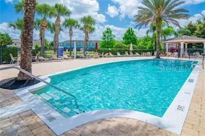 a view of swimming pool with lawn chairs and a patio