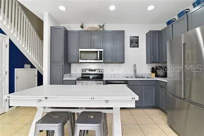 a kitchen with a appliances a sink and a refrigerator