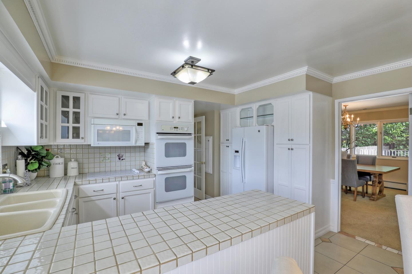 19923 Lanark Lane Saratoga, CA 95070 - Photo 12 of 34 a room with kitchen island a sink a stove and cabinets