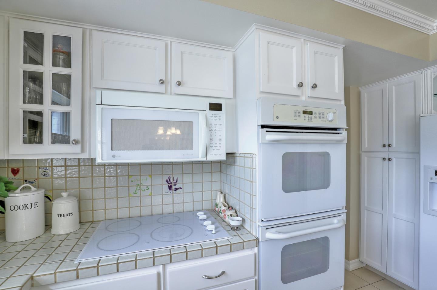 19923 Lanark Lane Saratoga, CA 95070 - Photo 13 of 34 a kitchen with granite countertop white cabinets and white appliances