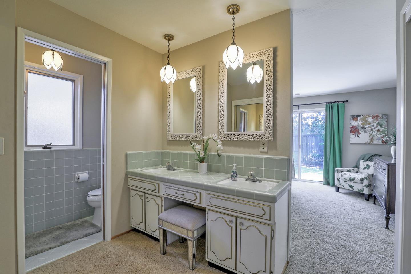 19923 Lanark Lane Saratoga, CA 95070 - Photo 25 of 34 a bathroom with a granite countertop sink a large mirror and a shower