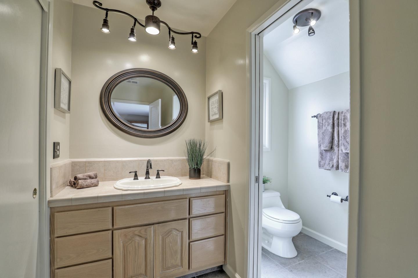 19923 Lanark Lane Saratoga, CA 95070 - Photo 26 of 34 a bathroom with a toilet a sink a mirror and vanity