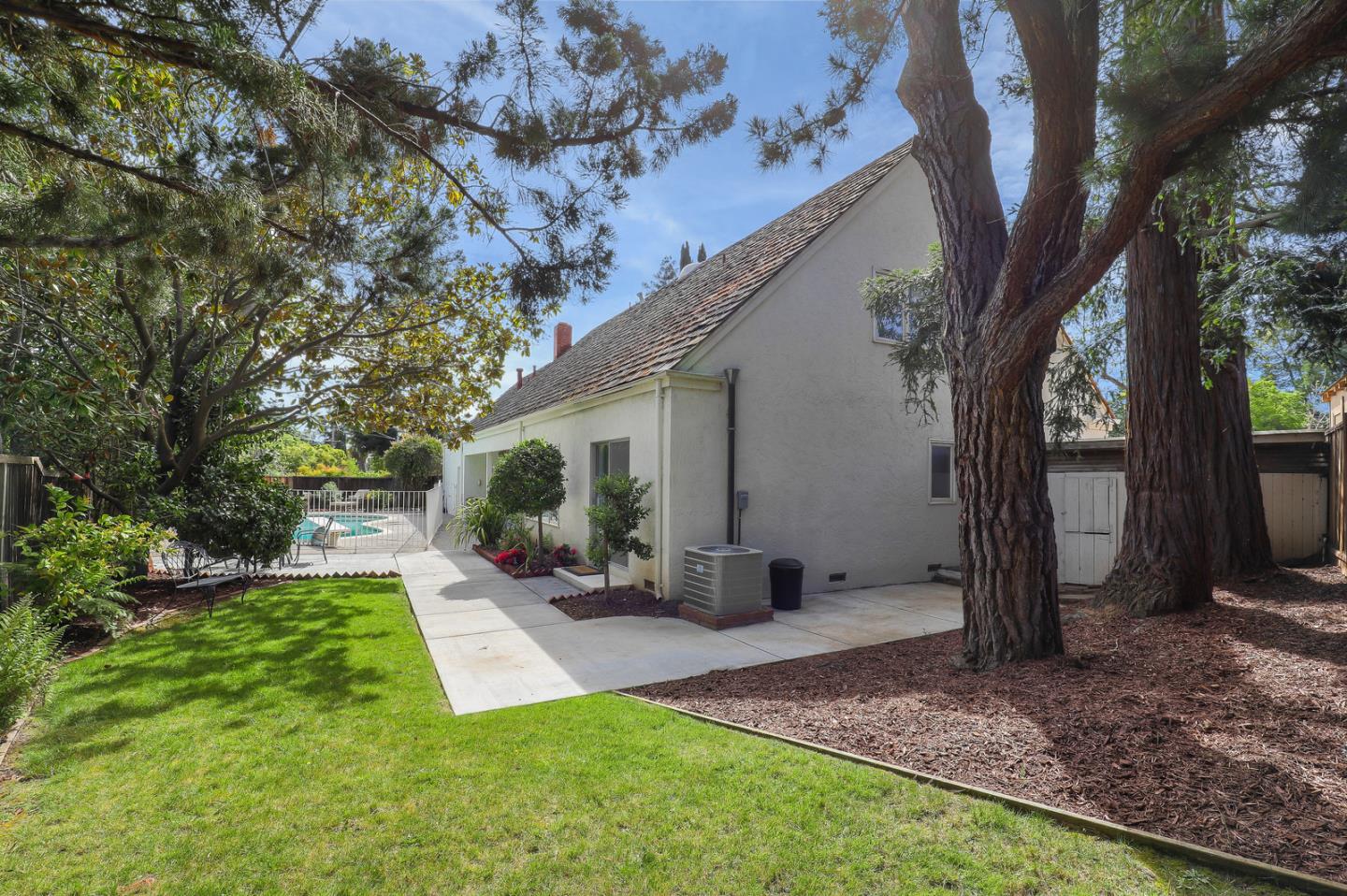 19923 Lanark Lane Saratoga, CA 95070 - Photo 28 of 34 a view of a backyard with table and chairs and a large tree