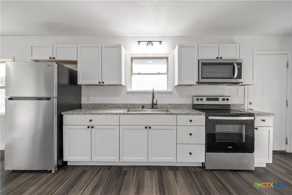 a kitchen with stainless steel appliances white cabinets and a sink