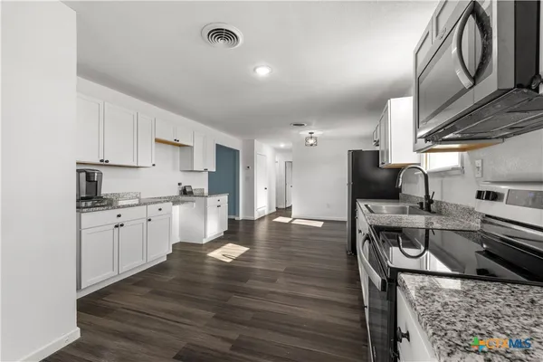 a kitchen with a sink appliances and cabinets