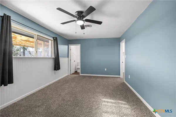 a view of a livingroom with a ceiling fan and window