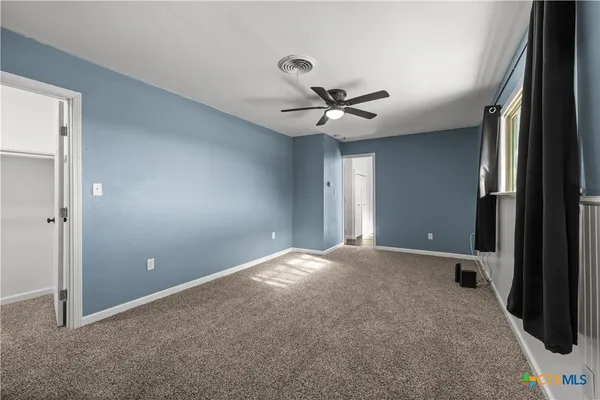 a view of an empty room with a ceiling fan