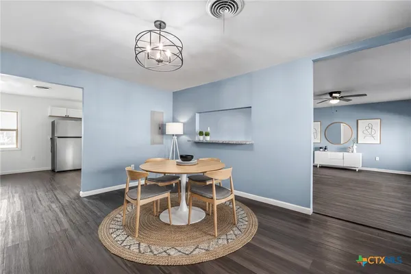 a view of a dining room with furniture a chandelier and wooden floor