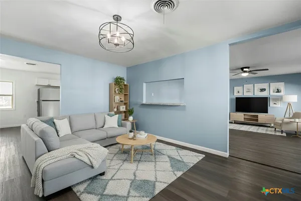 a living room with furniture and a chandelier