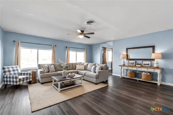a living room with furniture and a wooden floor