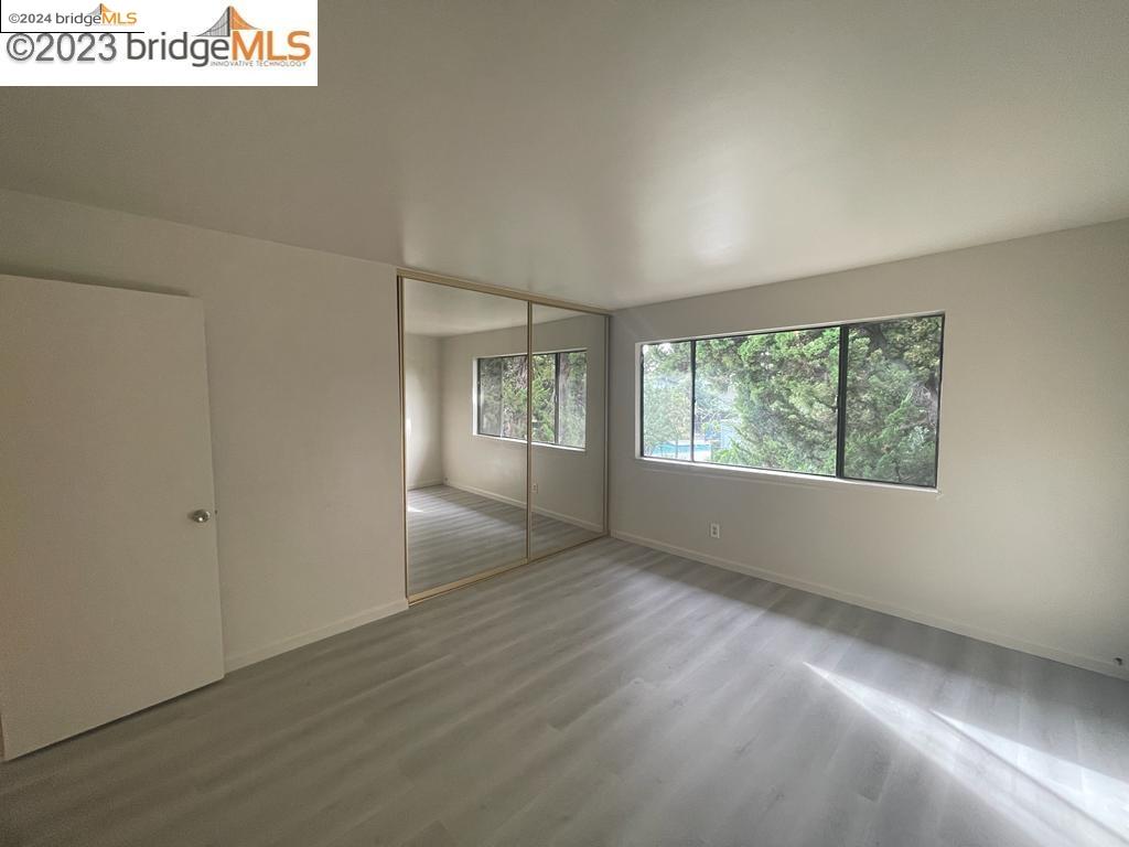 1096 Mohr Lane Concord, CA 94518 - Photo 11 of 34 an empty room with wooden floor and windows