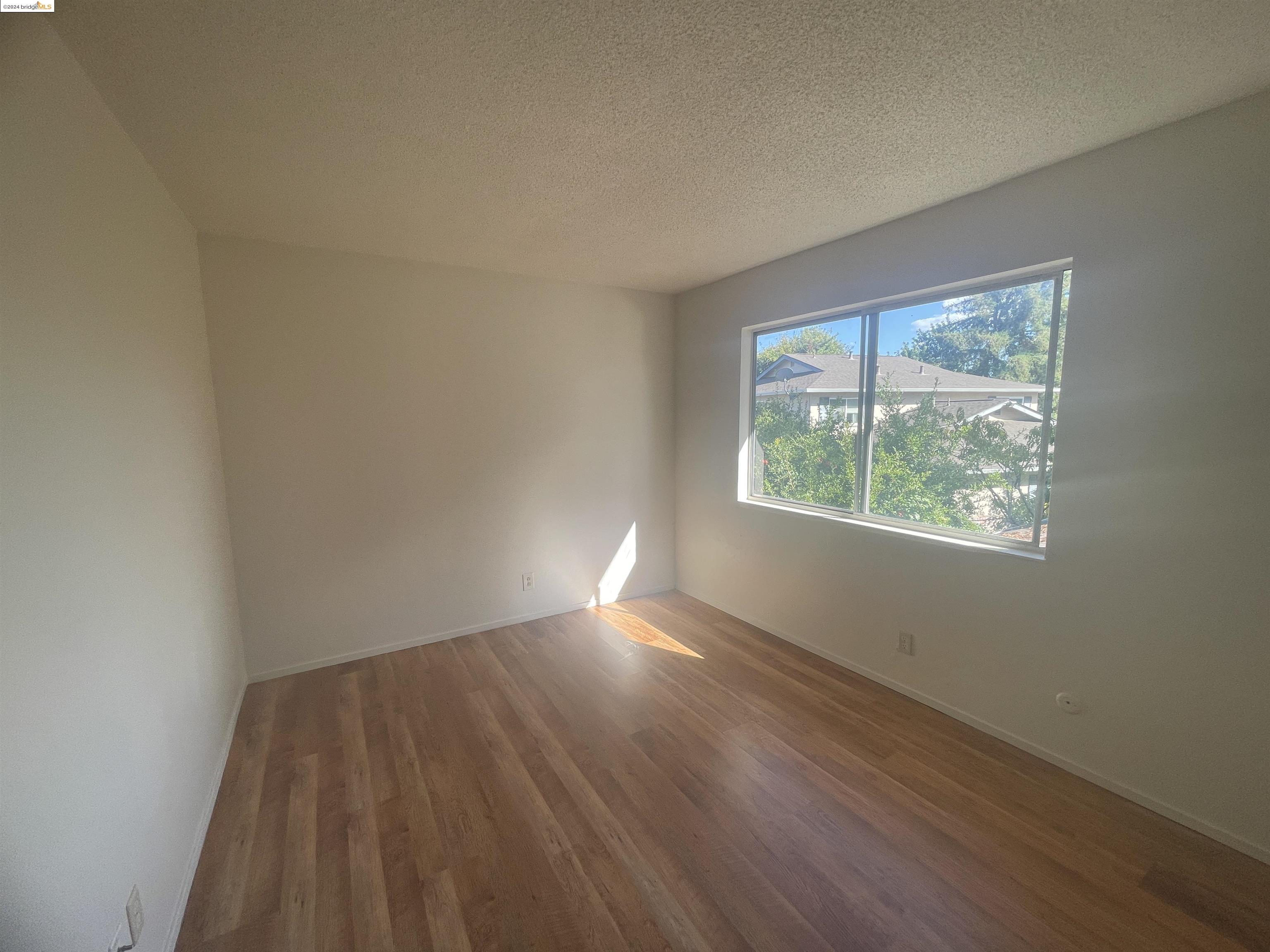 1096 Mohr Lane Concord, CA 94518 - Photo 27 of 34 an empty room with wooden floor and windows