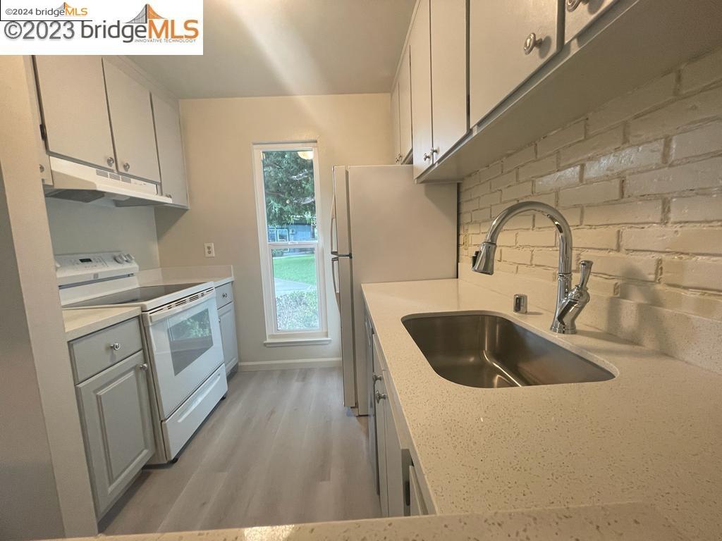 1096 Mohr Lane Concord, CA 94518 - Photo 6 of 34 a kitchen with white cabinets and sink