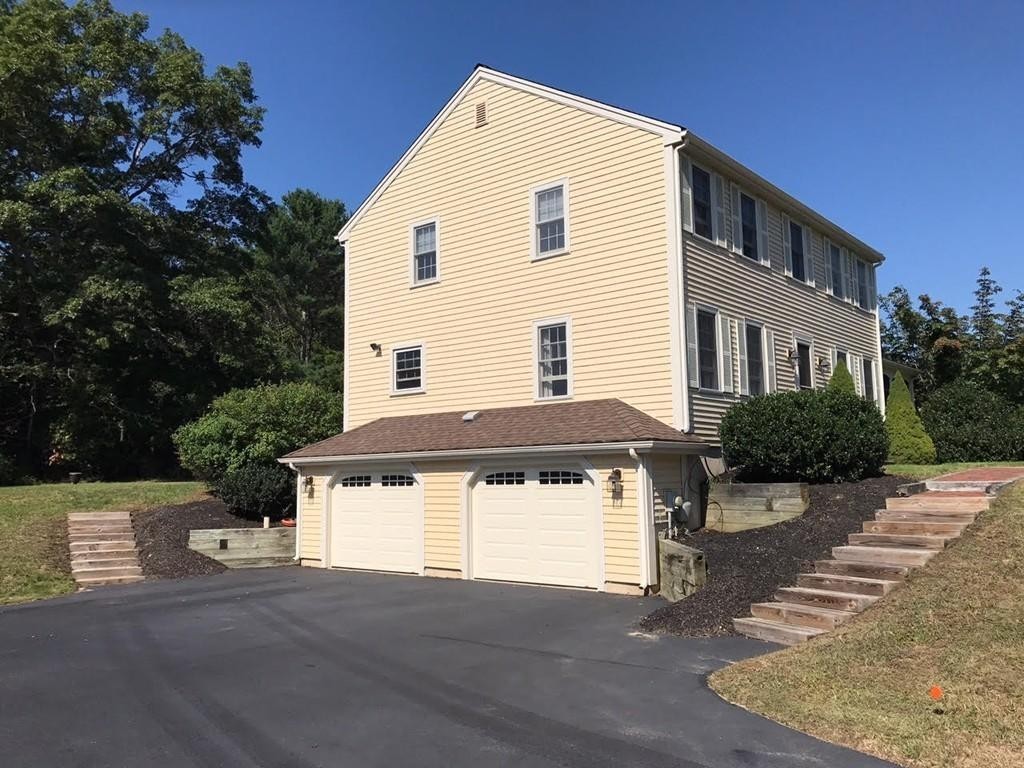 20 Meadow Lane Rochester, MA 02770 - Photo 4 of 26 a front view of a house with a yard and garage
