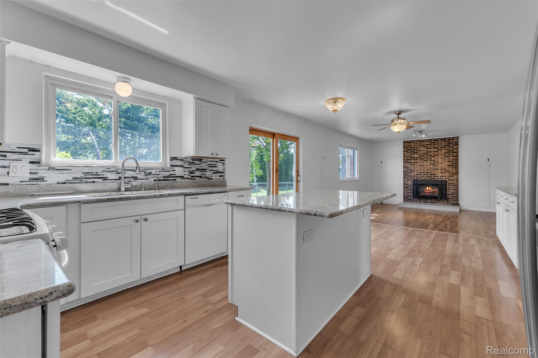 7000 Woonsocket Street Canton, MI 48187 - Photo 15 of 65 Open-concept kitchen featuring white cabinetry, granite countertops, and a mosaic tile backsplash