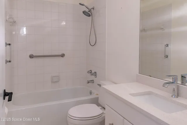 a bathroom with a granite countertop sink a toilet and shower