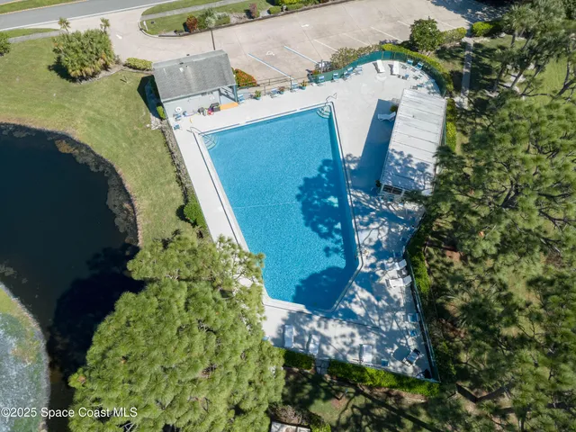 a view of a swimming pool with a lawn chairs under an umbrella