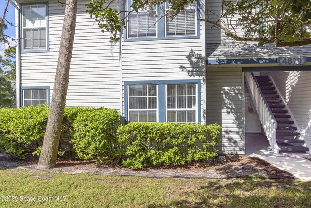 a view of a house with backyard and tree