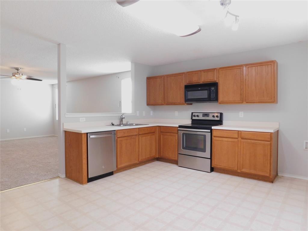 5721 Thoroughbred Trail Denton, TX 76210 - Photo 7 of 24 a kitchen with stainless steel appliances granite countertop a stove a sink and a refrigerator