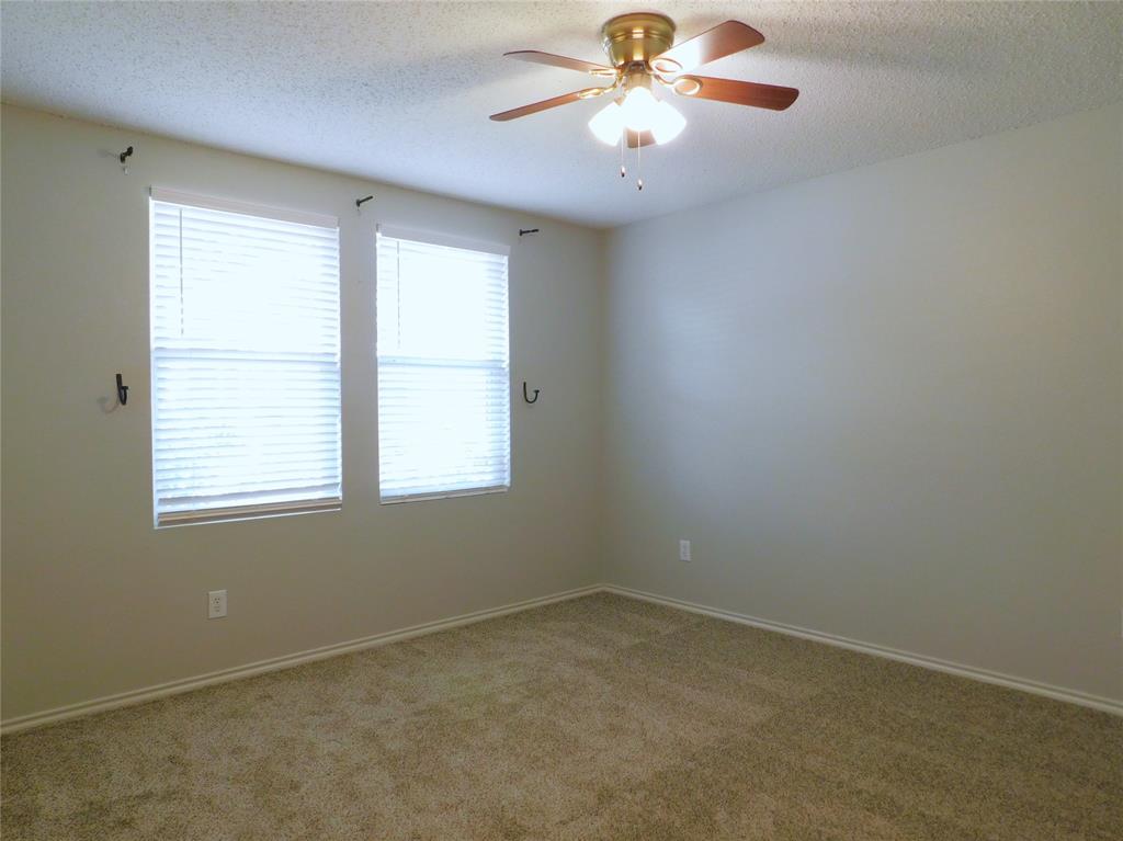 5721 Thoroughbred Trail Denton, TX 76210 - Photo 9 of 24 an empty room with a window and a fan