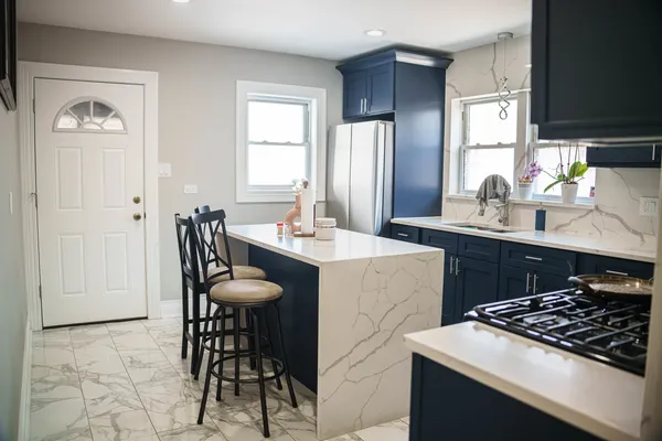 a kitchen with stainless steel appliances a dining table and chairs