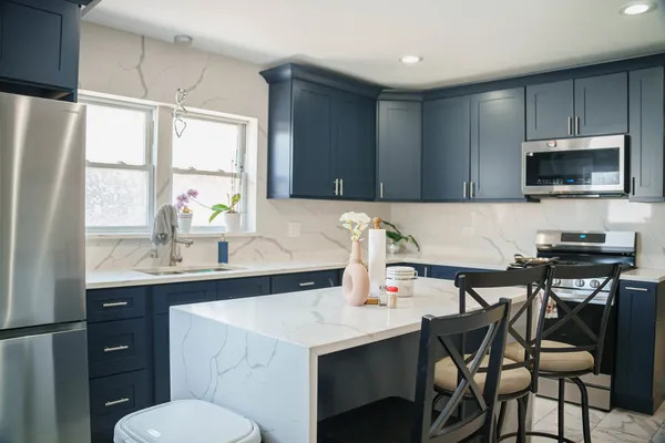 a kitchen with a stove a sink a microwave a dining table and chairs