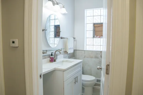 a bathroom with a sink vanity mirror and toilet