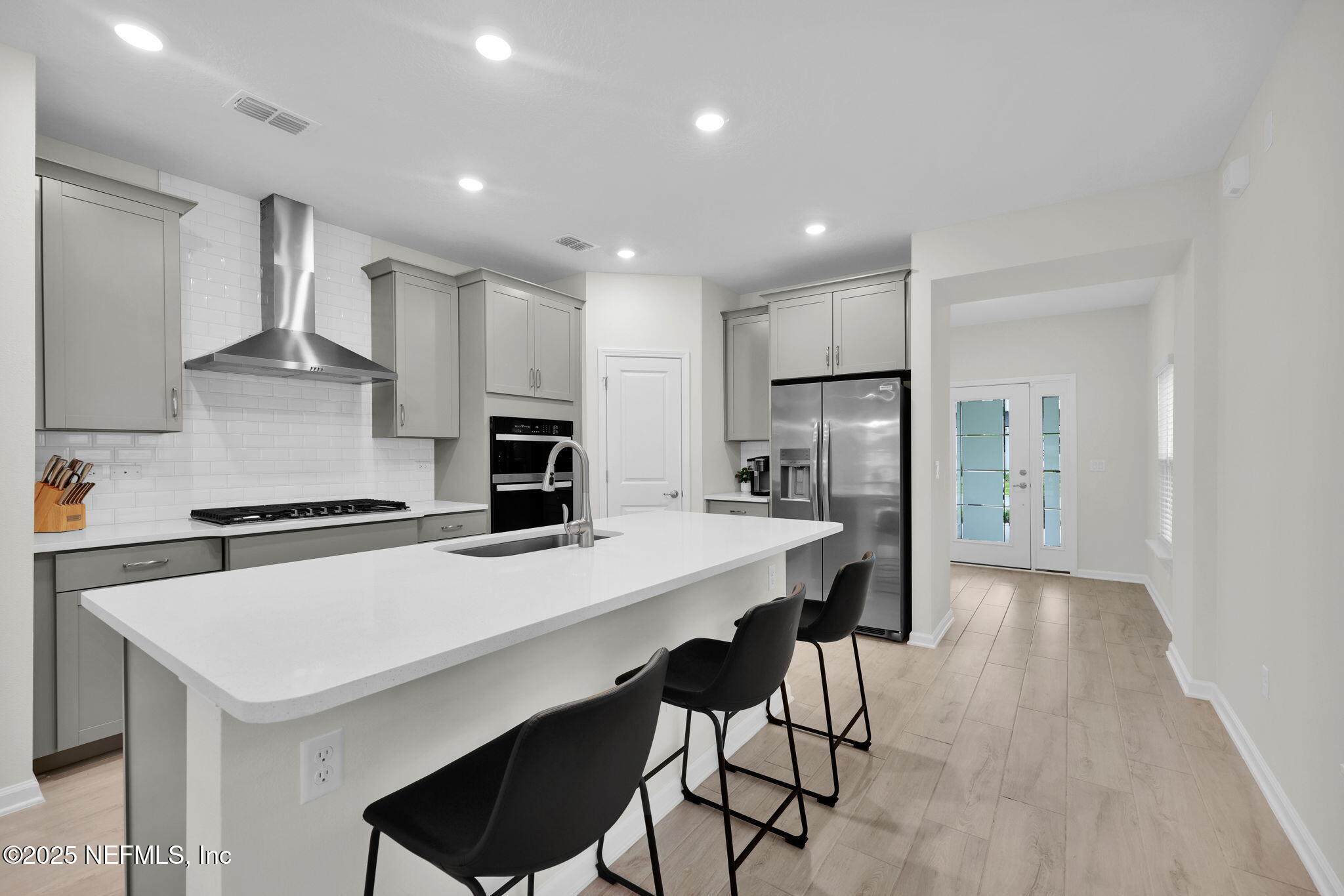 87 Whirlwind Place St. Augustine, FL 32095 - Photo 3 of 44 a kitchen with stainless steel appliances a stove top oven a refrigerator a sink and a refrigerator with wooden floor