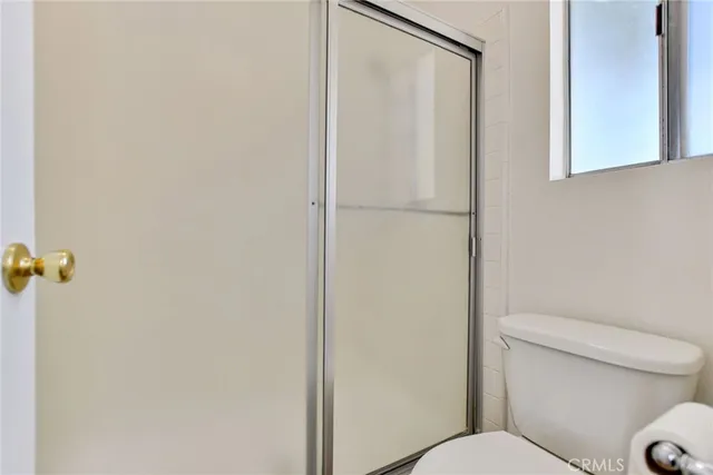 a white toilet sitting next to a shower