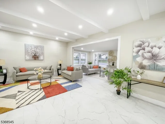 a living room with furniture flowerpot and wooden floor