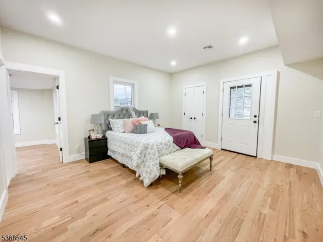 a spacious bedroom with a bed and a wooden floor