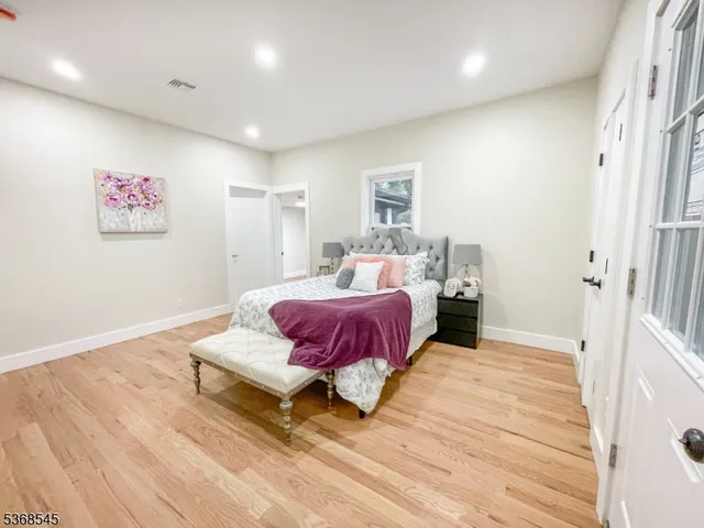a spacious bedroom with a bed and a painting on the wall