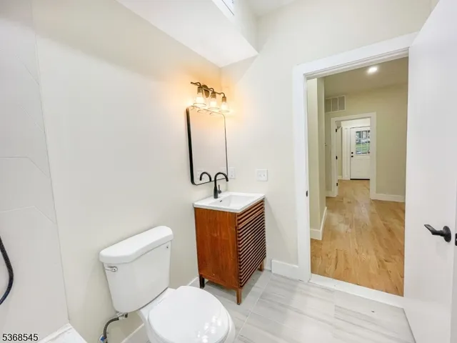 a bathroom with a toilet a sink and mirror