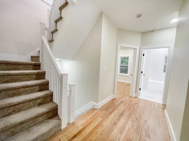 a view of a hallway with wooden floor and entryway