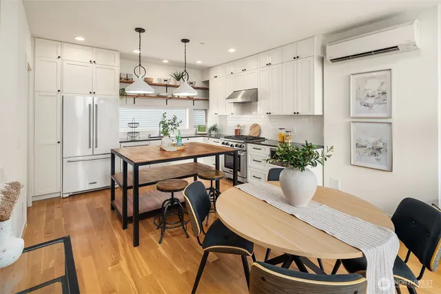 a room with stainless steel appliances a dining table chairs and view kitchen