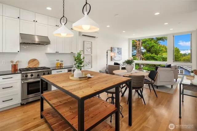 a kitchen with stainless steel appliances a table chairs refrigerator and cabinets